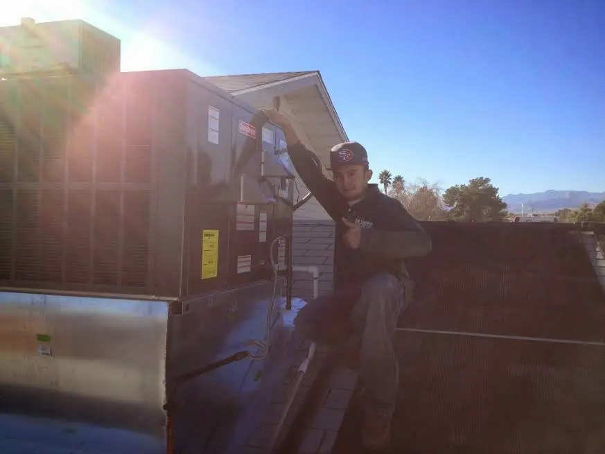 HVAC technician performing Air Duct Repair on a rooftop unit in Portsmouth